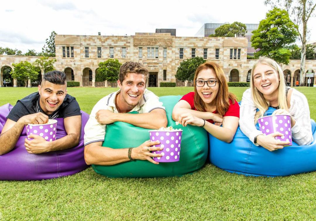 Three students sitting on the grass in the Great Court 