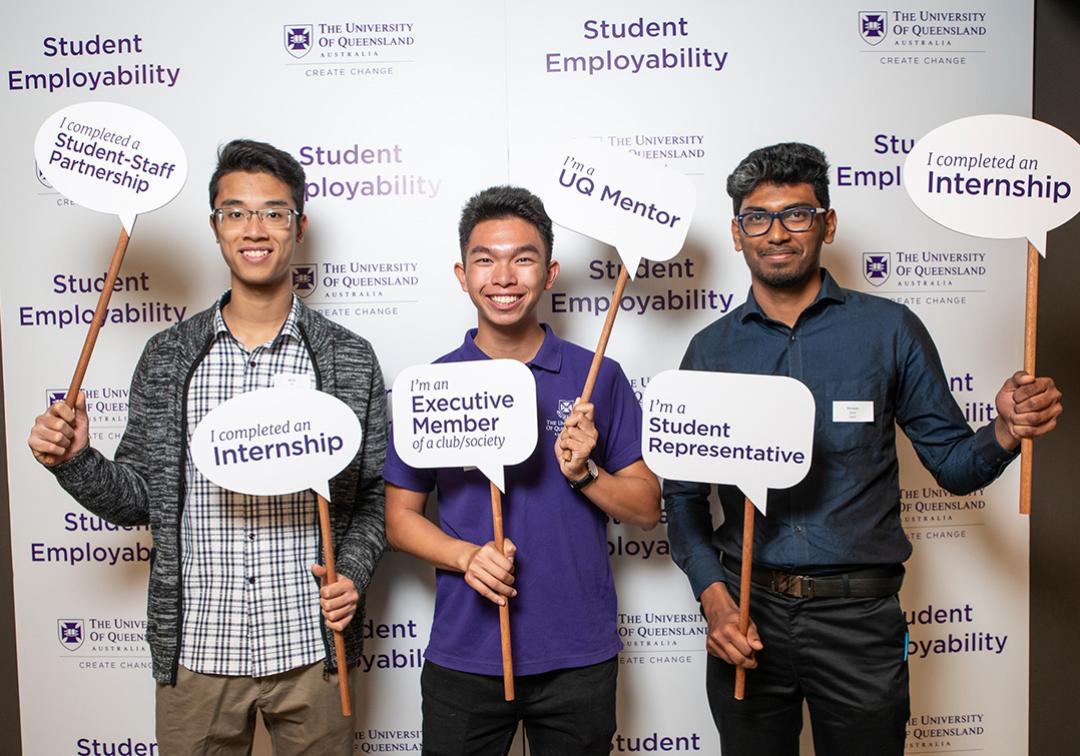 Three students holding employability signs
