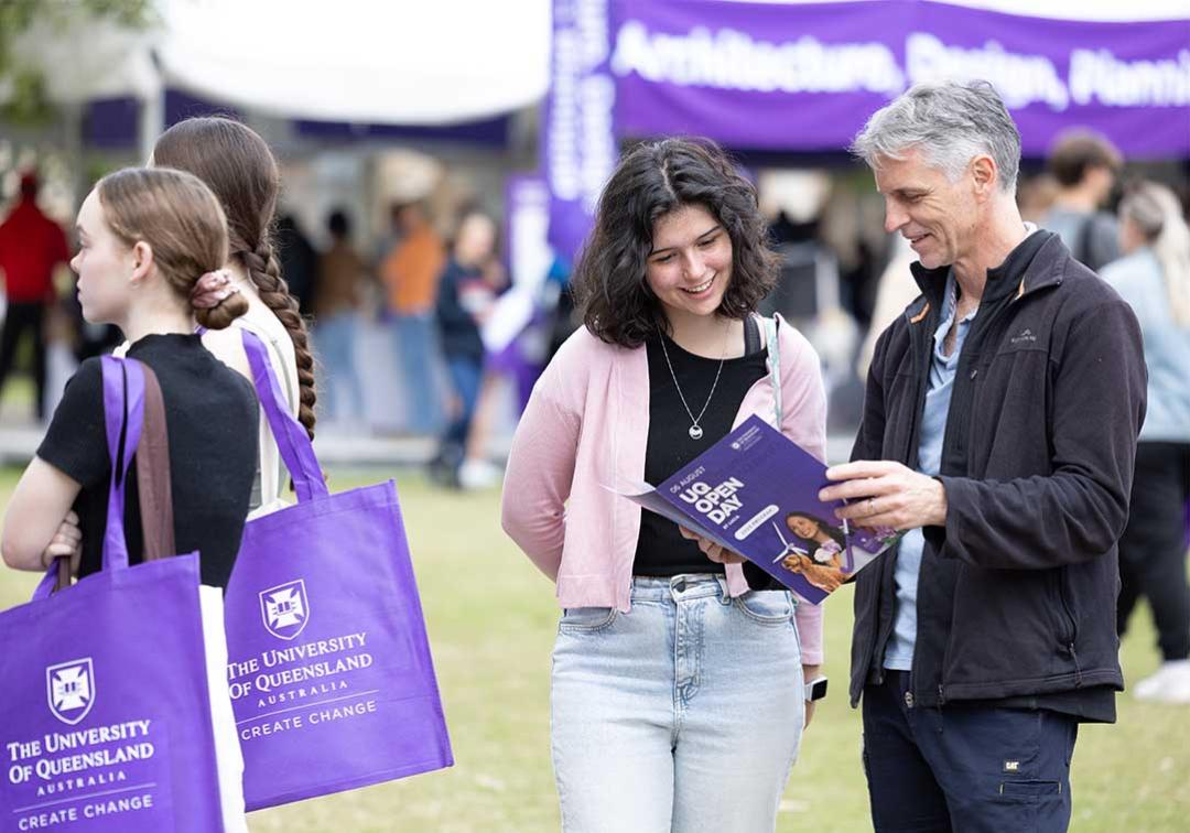 Father and daughter look at brochure at UQ Open Day