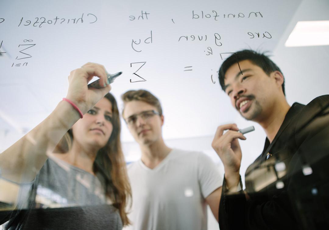 UQ mathematics students draw equations on glass