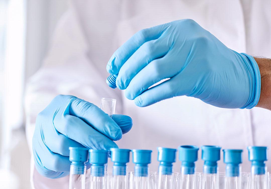 Researcher putting caps on a row of test tubes