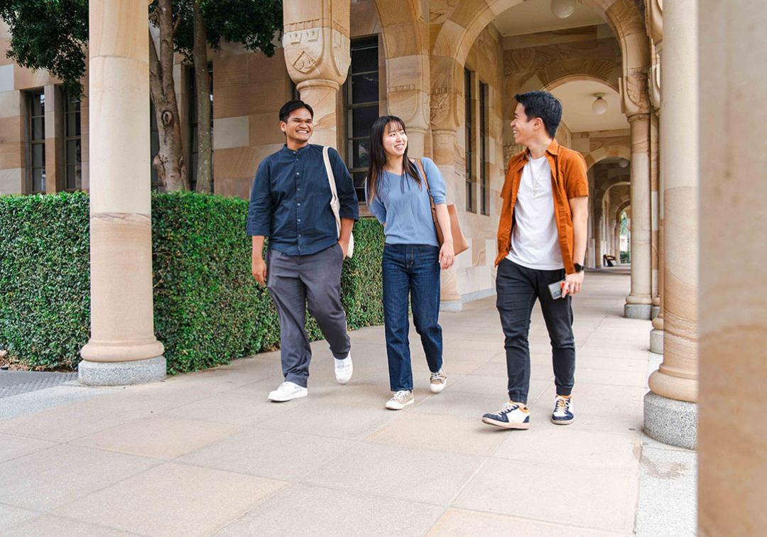 UQ students walk through the sandstone cloisters at St Lucia campus