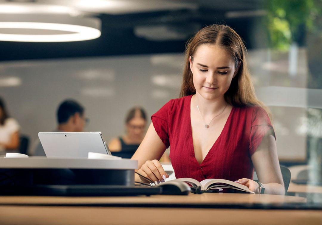 Student reading a book in a UQ study space