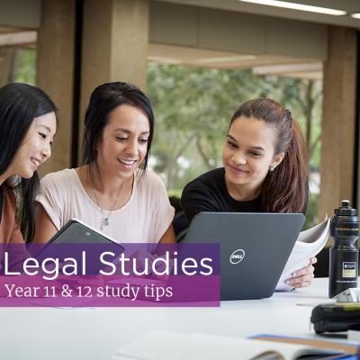 Three friends sit studying Legal Studies with laptop