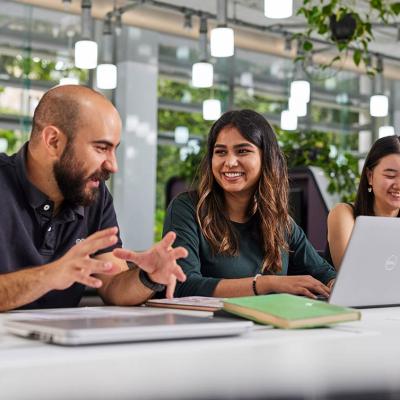 UQ students studying in light-filled classroom at desks with laptops