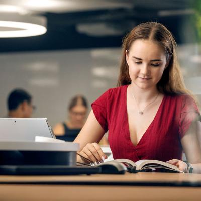 Student reading a book in a UQ study space