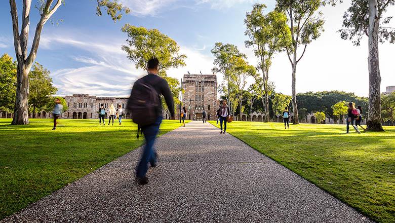 A UQ student walks down a path in the centre of St Lucia campus' Great Court