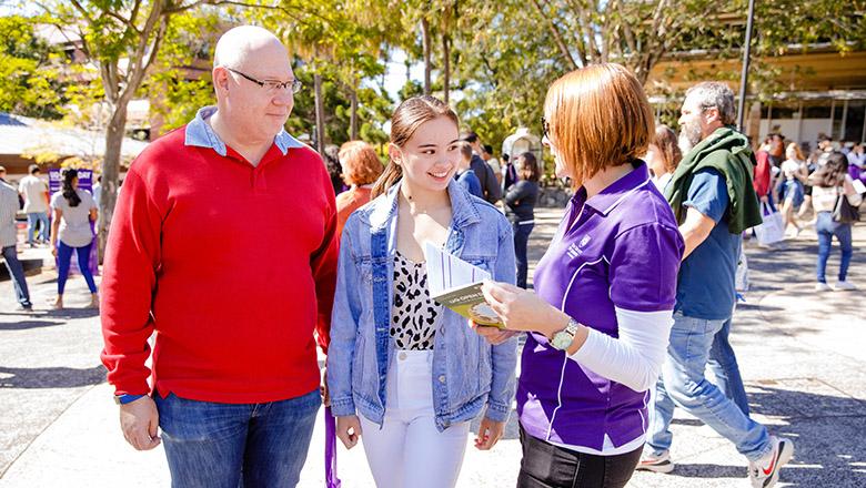 A father and daughter get advice from a staff member at UQ Open Day