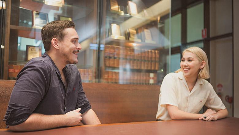 Law students sit chatting in the UQ Law Library