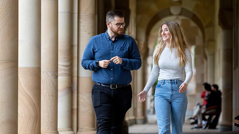 Lecturer Sean Peel and student Maddison Pledger-Dunn walk the sandstone halls of UQ