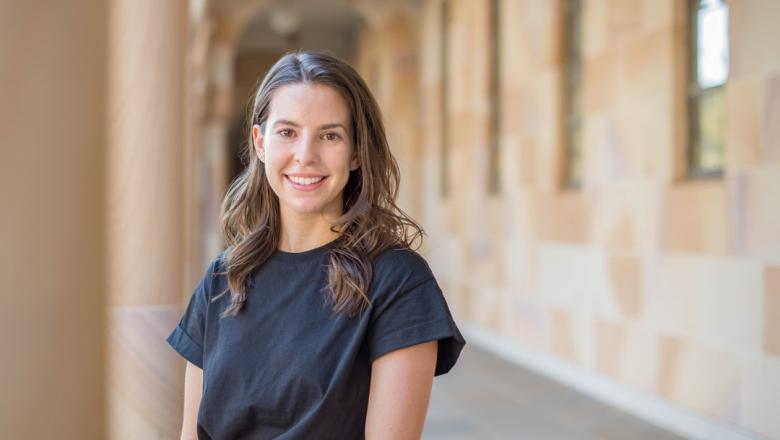 Megan Gannon stands in front of the sandstone cloisters of UQ's St Lucia campus Great Court