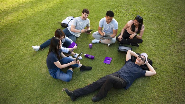 A group of students sitting on the grass in a circle