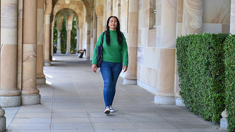 Jaala Ozies walks through the sandstone cloisters of UQ St Lucia campus' Great Court