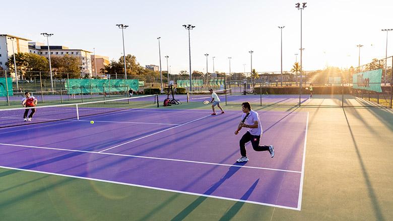People playing tennis on purple courts