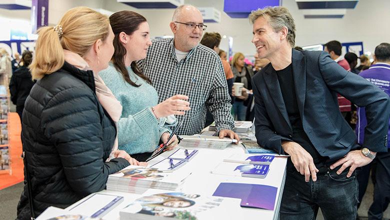 Prospective students and a parent talks to staff member at TSXPO