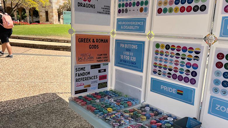 Pride market stall at UQ showing colourful badges