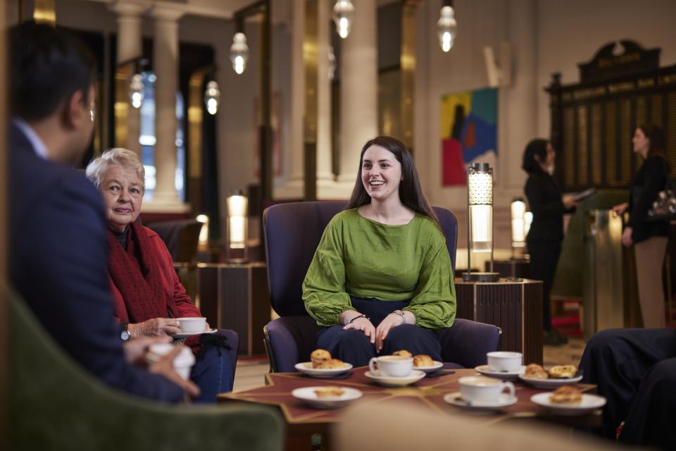 Alumni sitting in the atrium