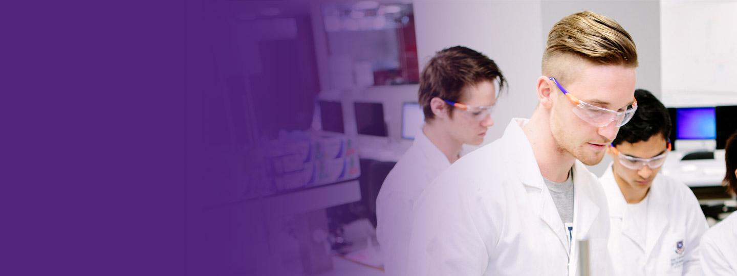 Students in white coats working in a science lab