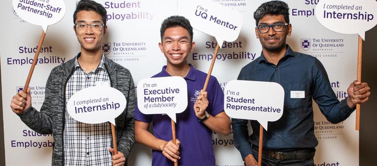 Three students holding employability signs