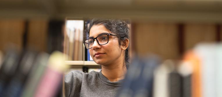Neeharika looking through books in the library