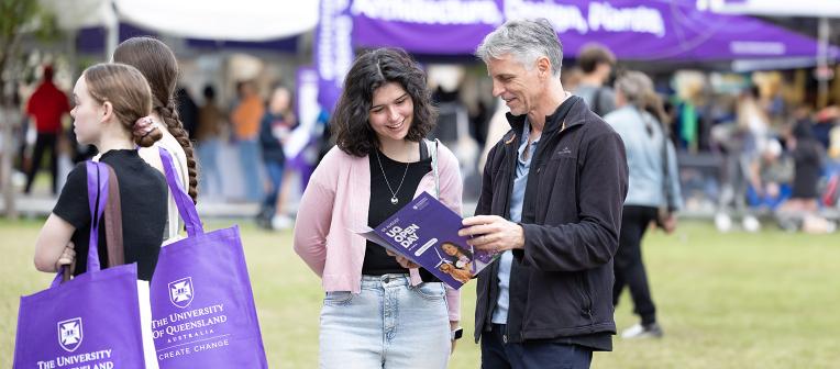 Father and daughter look at brochure at UQ Open Day