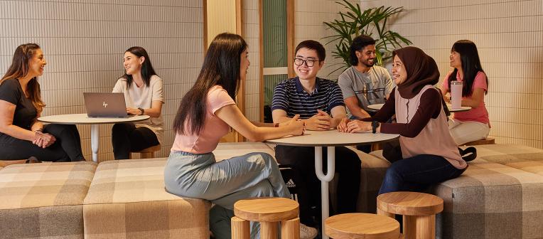 UQ students sitting at a table chatting