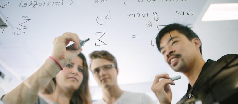 UQ mathematics students draw equations on glass