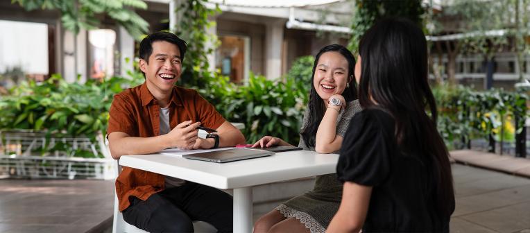 Jeremy Kester Hanani and fellow students chatting around a table outdoors