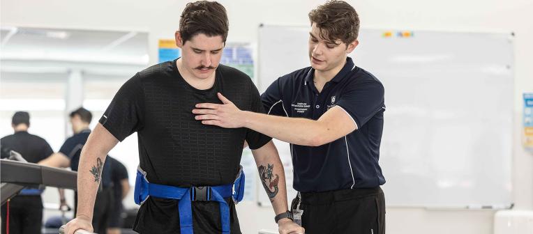 Physiotherapy student assist patient in rehab exercises
