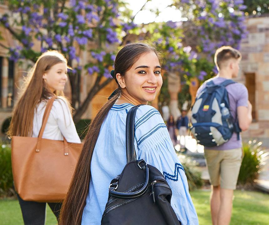Student wearing a backpack looking over her shoulder.