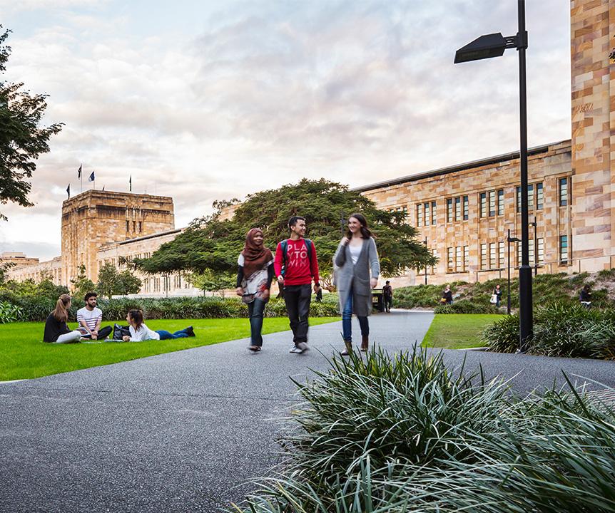 Students walking along a footpath with UQ's Forgan Smith building in the background.