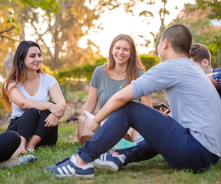 Friends chatting while sitting on a lawn