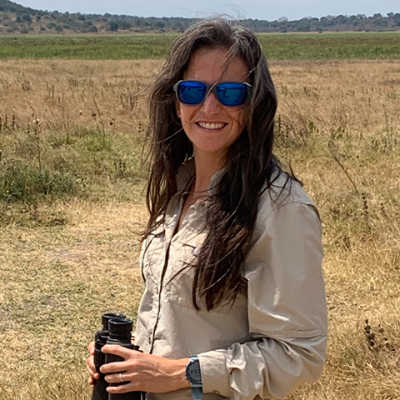 Monica Alvarez Malvido out in a field with binoculars.