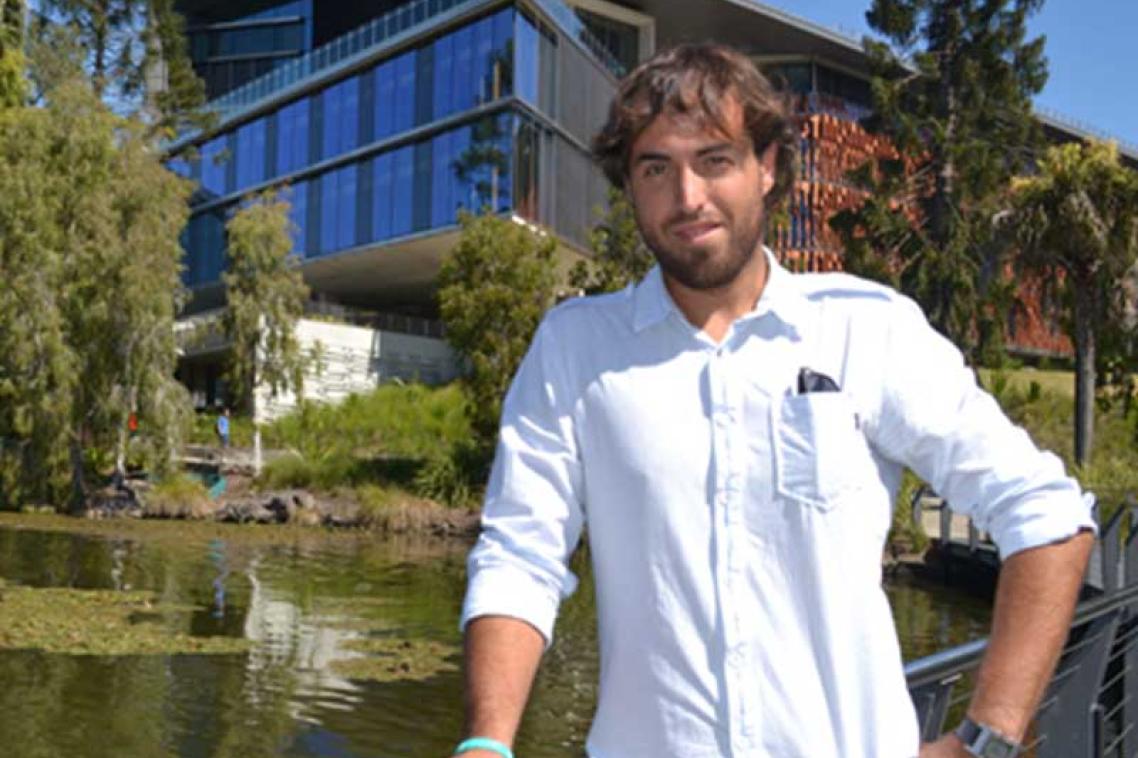 Diego Montiel standing in front of the UQ lakes and Advanced Engineering Building.