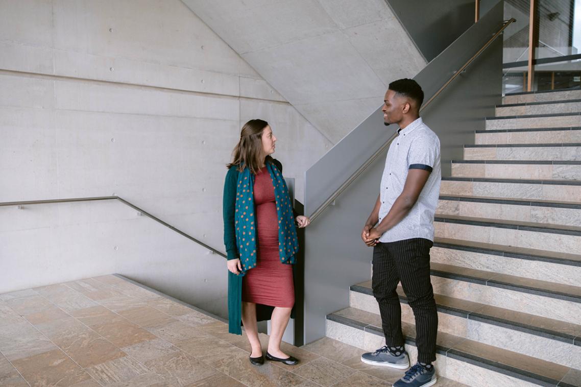 student and lecturer standing together talking