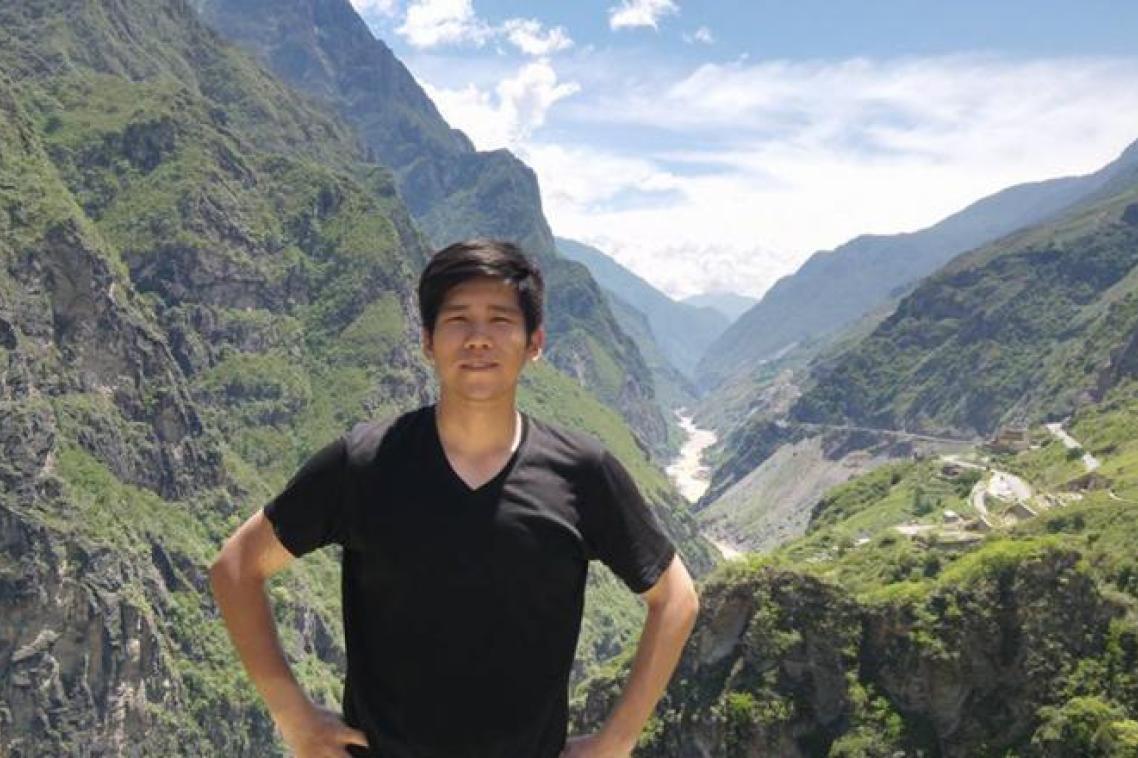 Bo Qiu standing in front of a mountain valley. 
