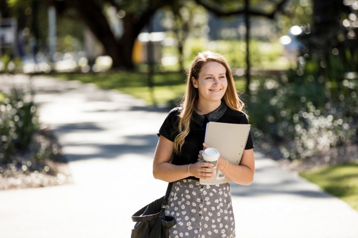 Female student walking across campus grounds