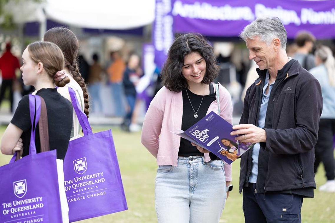 Father and daughter look at brochure at UQ Open Day