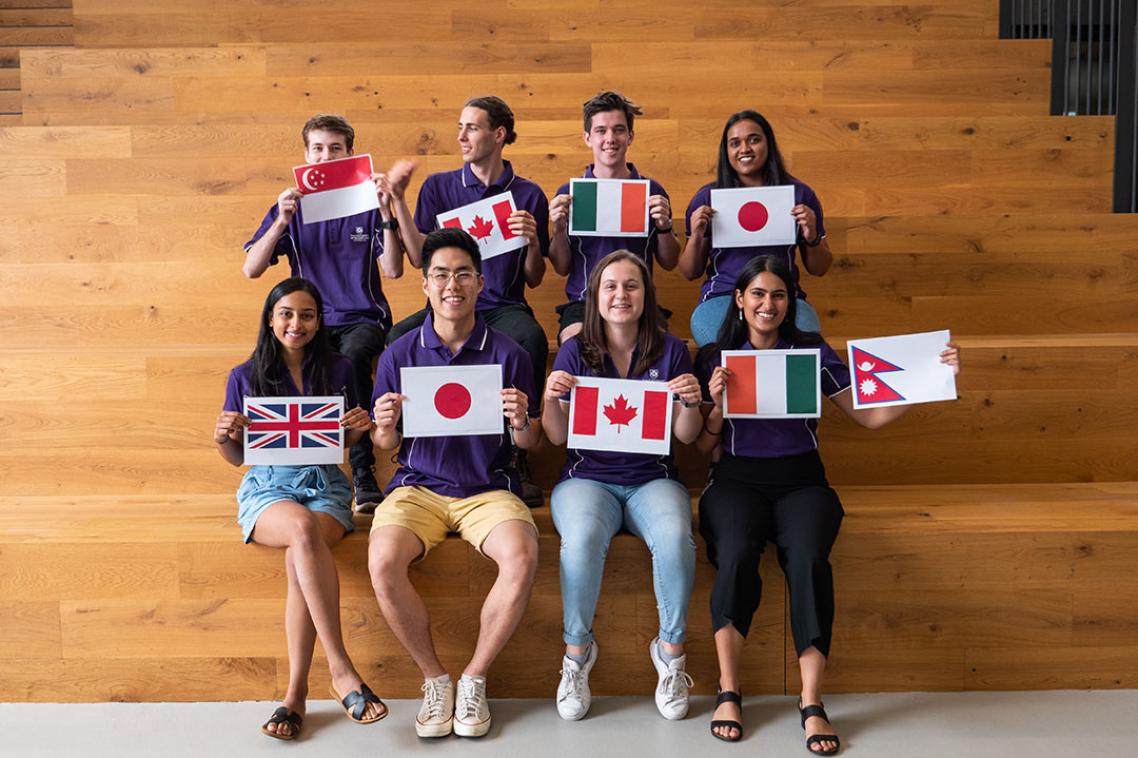 A group of students holding flags from various nations