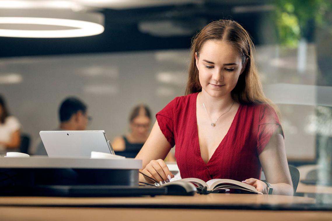 Student reading a book in a UQ study space