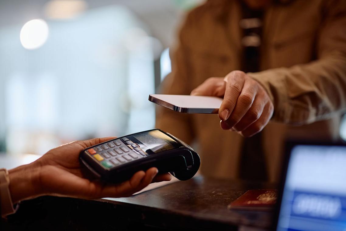 A person holds a phone to an eftpos machine