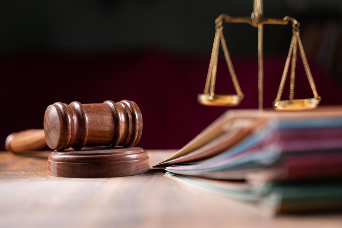 A judge's gavel sits next to the scales of justice